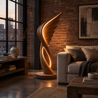 Winged floor lamp with layered feathers and a glowing oval loop in an industrial loft living room with exposed brick