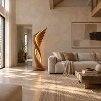 Winged floor lamp with layered feathers and a glowing oval loop in a bright open plan living room