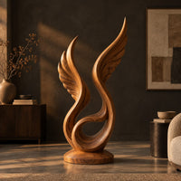 Winged swirl sculpture with carved feather lines on a disc base in a dark living room at golden hour