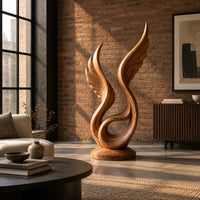 Winged swirl sculpture with carved feather lines on a disc base in an industrial loft living room with exposed brick