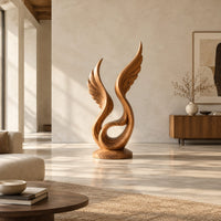 Winged swirl sculpture with carved feather lines on a disc base in a bright open plan living room