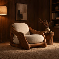 Lounge chair with a carved wooden frame and soft cream cushions in an evening living room with walnut wall paneling