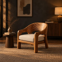 Wraparound lounge chair with arched cutout arms and an upholstered seat in a dark living room at golden hour