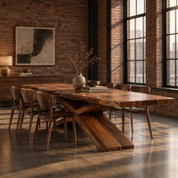 Dining table with crossed legs and a thick rectangular top in an industrial loft dining room with exposed brick