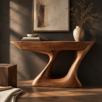 Corner detail of console table with an angular two panel top on a sculpted z base beside wood, brass and linen samples