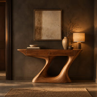 Console table with an angular two panel top on a sculpted z base in a dark entryway at golden hour