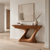 Console table with an angular two panel top on a sculpted z base in a Scandinavian entryway with white walls