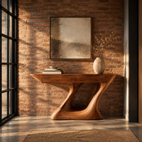 Console table with an angular two panel top on a sculpted z base in an industrial loft entryway with exposed brick