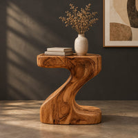 Z shaped side table with a thick top and a flowing sculpted body, three-quarter view showing the grain