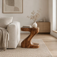 Z shaped side table with a thick top and a flowing sculpted body in a Scandinavian living room with white walls