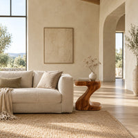 Z shaped side table with a thick top and a flowing sculpted body in a bright open plan living room