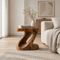 Z shaped side table with a carved diagonal opening and wide base in a Scandinavian living room with white walls
