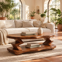 Oval coffee table with zigzag supports and a wavy edged lower shelf in a bright living room with arched windows and plants