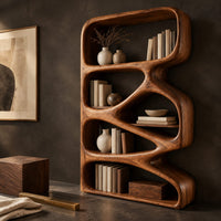 Corner detail of bookshelf with five open compartments in a zigzag ribbon frame beside wood, brass and linen samples