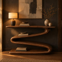 Console table with a continuous zigzag ribbon base and a flat slab top in a dark entryway at golden hour
