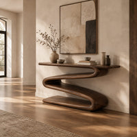 Console table with a continuous zigzag ribbon base and a flat slab top in a bright open plan entryway